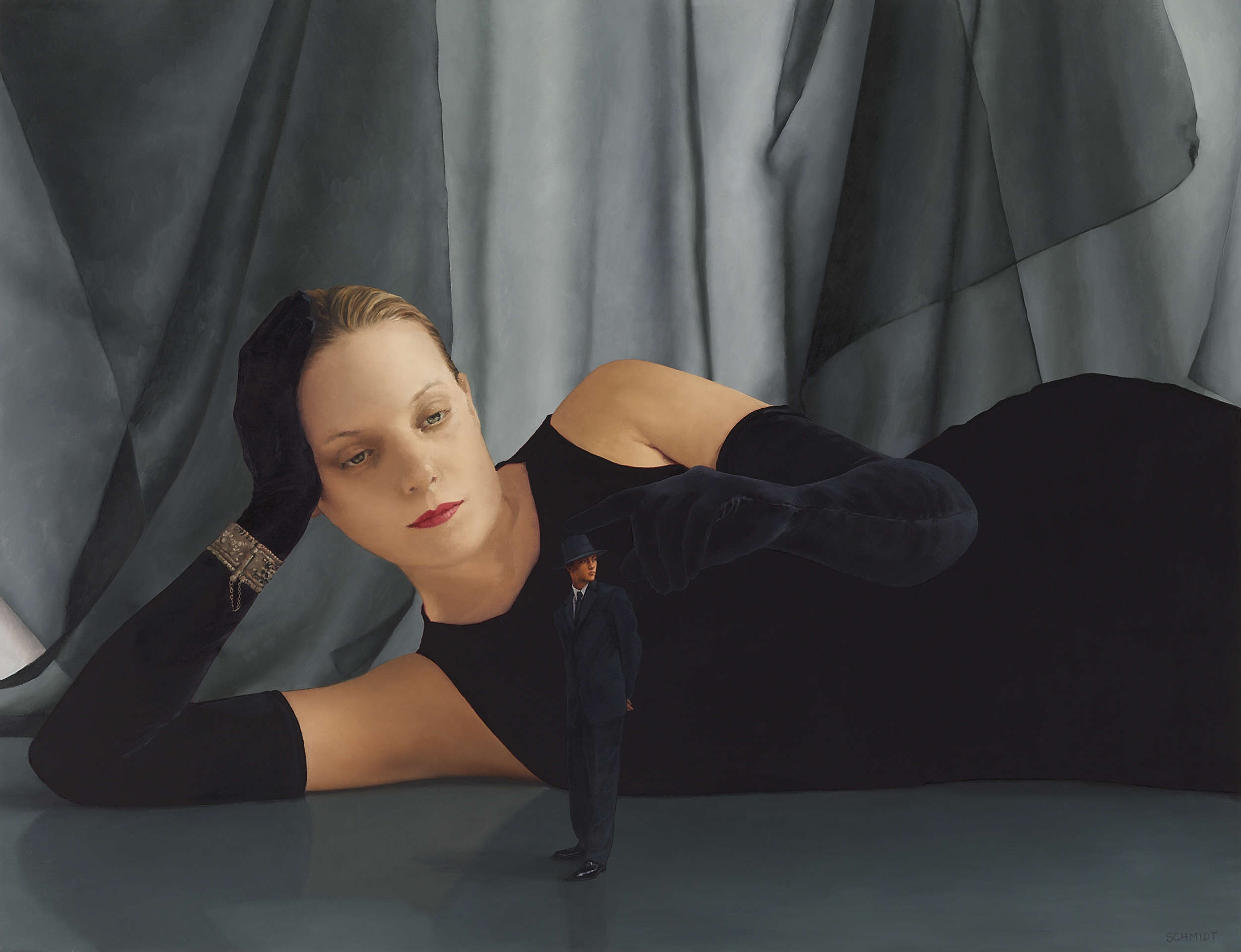female figure (Cecile) lying on floor wearing black long gloves and a black dress,  diminutive man dressed in a suit and fedora hat  (black transparent fabric behind)