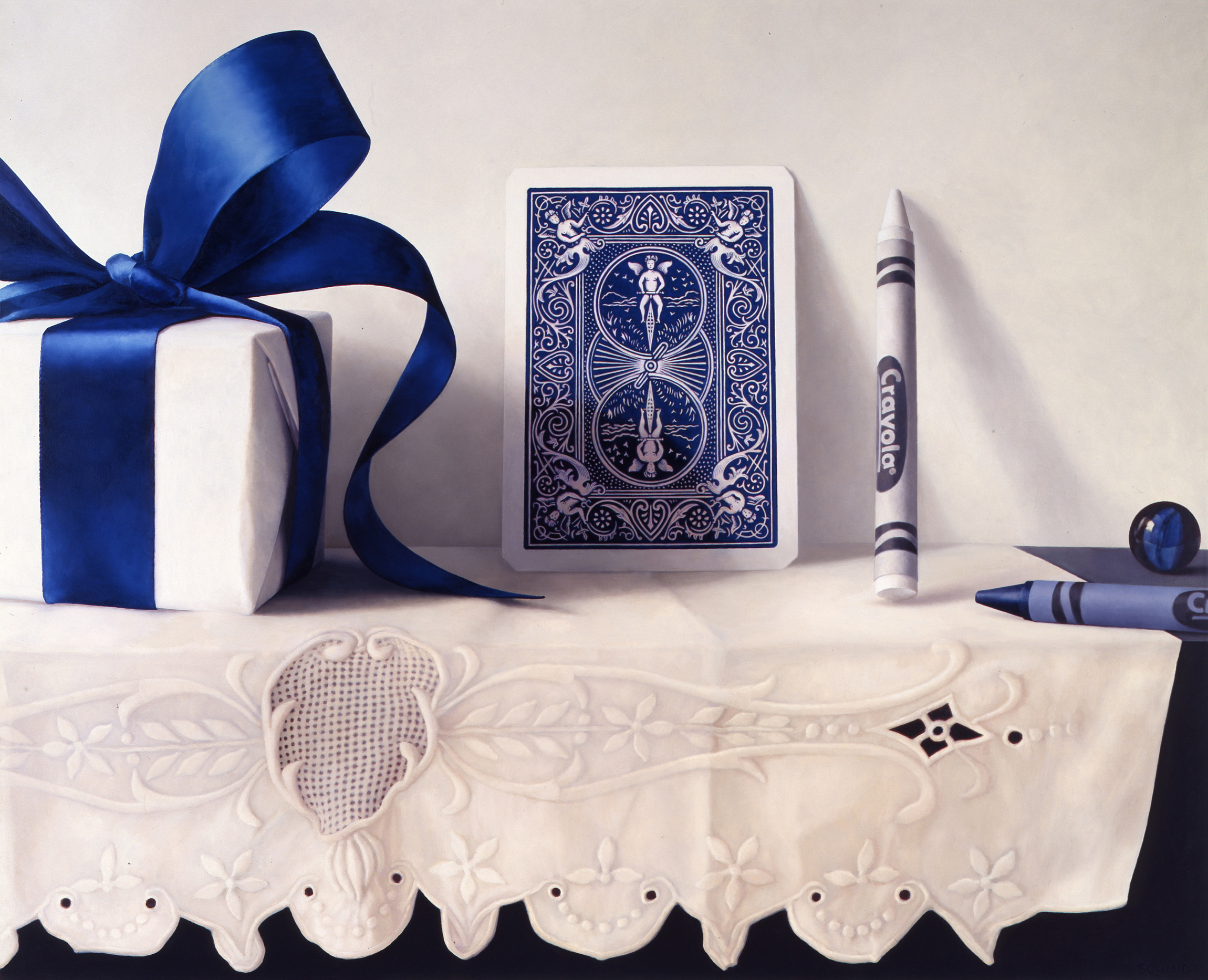 giant gift box, white with blue satin ribbon, blue and white side of playing card, marbles, crayola crayons, embroidered cloth