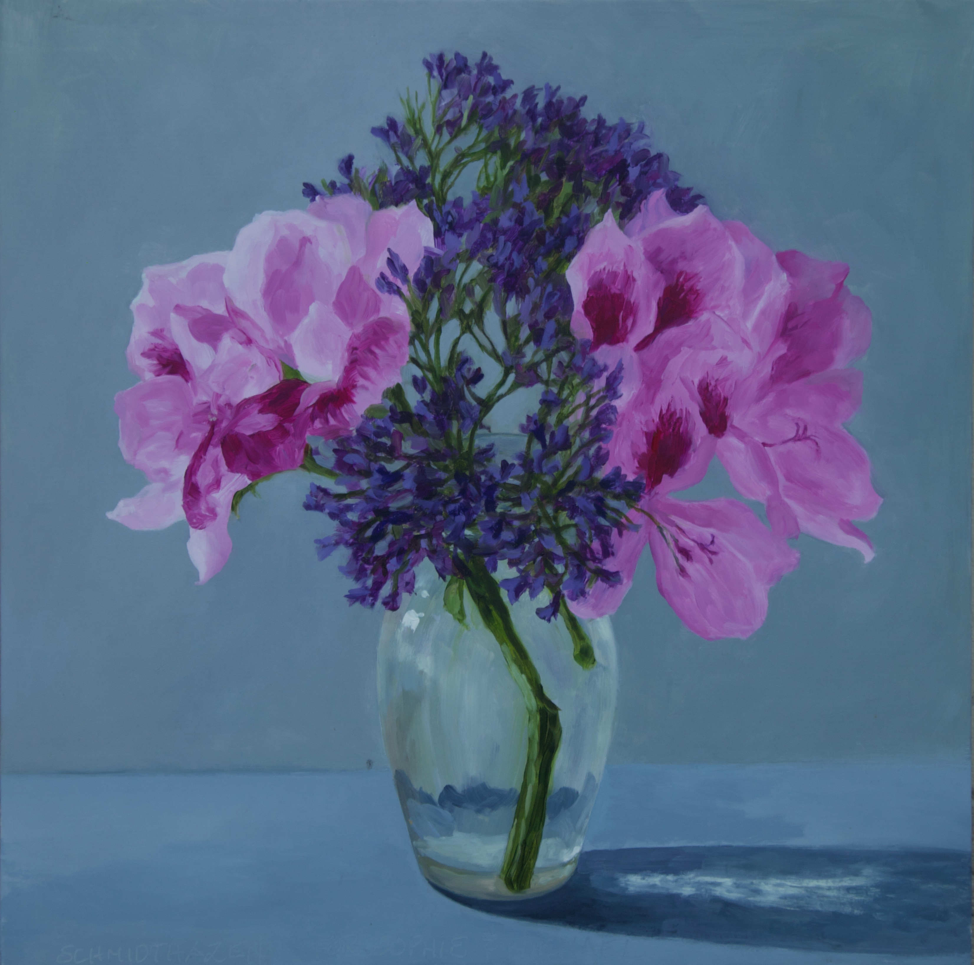 Pink azaleas and purple flowers in glass vase with blue gray background and shadows